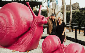 Sculptureum owner Anthony Grant with Pink Snails by the Cracking Art Group