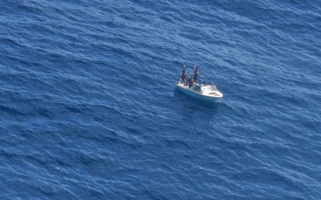 The three fishermen wave to the NZDF Orion.