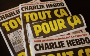 This picture taken on September 1, 2020 in Paris shows covers of French satirical weekly Charlie Hebdo reading "All of this, just for that," to be published on September 2 to mark this week's start of the trial for 14 accused in January 2015 jihadist attacks in Paris.