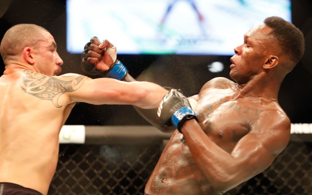 Robert Whittaker of Australia throws a punch at Israel Adesanya of New Zealand during UFC 243.