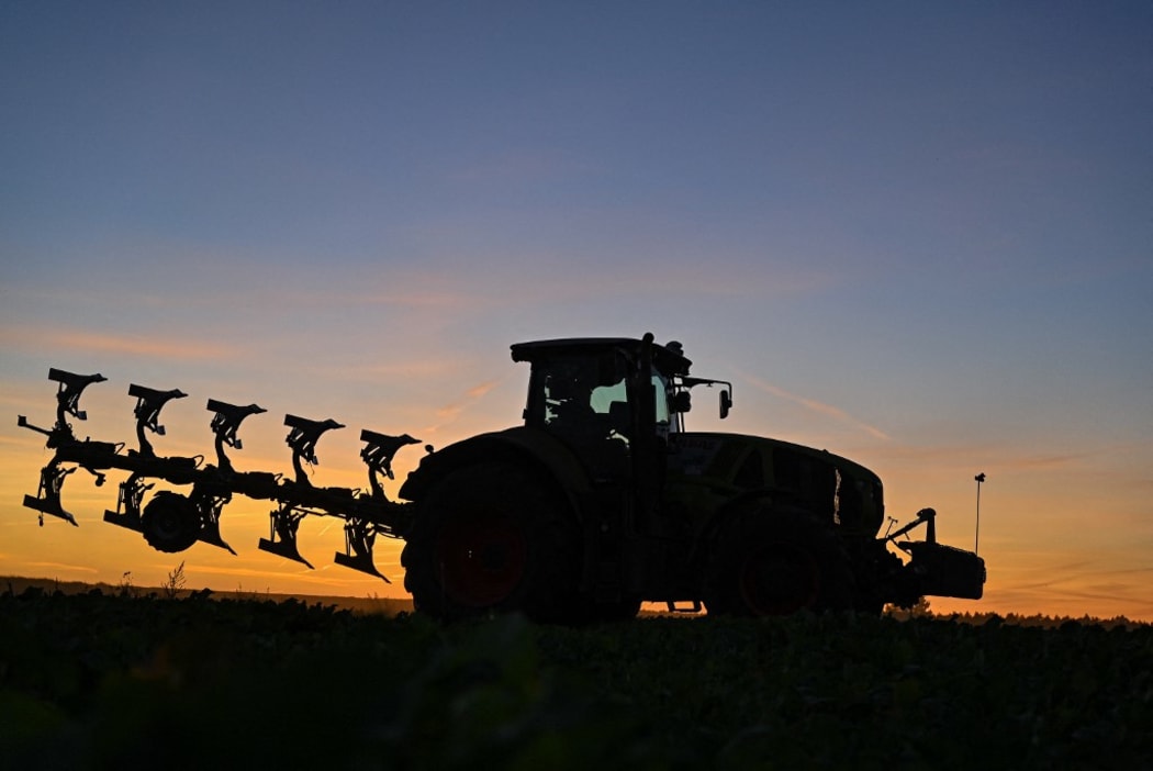 18 September 2020, Brandenburg, Sieversdorf: A farmer drives a tractor and a plough over a field at sunset. Photo: Patrick Pleul/dpa-Zentralbild/ZB