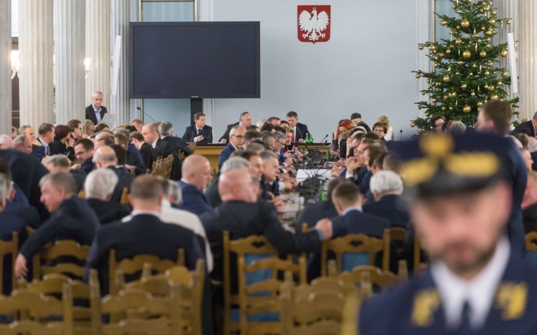Governing party Law and Justice (PiS) parliamentarians during the controversial session of Polish parliament at the Column Hall of the Sejm, as opposition parties parliamentarians occupy the the podium in the plennary hall at Sejm in Warsaw.