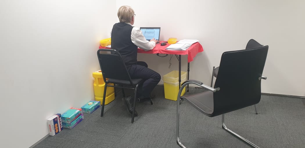 Dr Brian Morton works at his desk in the vaccination clinic.