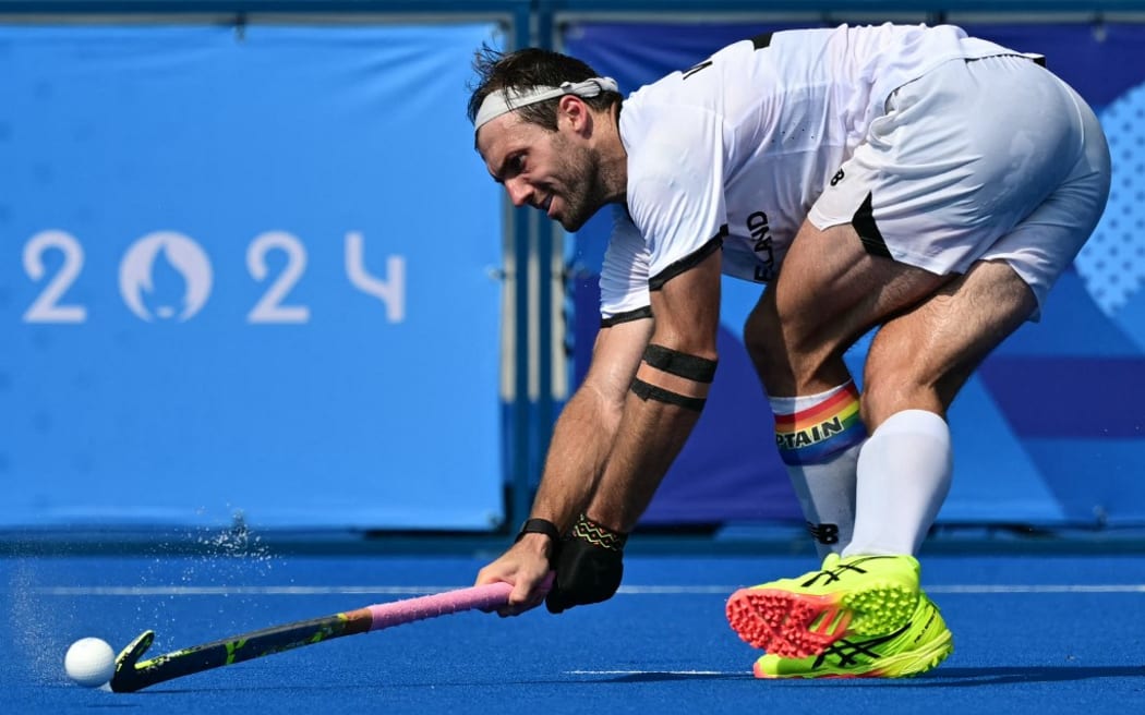 New Zealand's midfielder #17 Nic Woods passes the ball in the men's pool B field hockey match between New Zealand and Australia during the Paris 2024 Olympic Games at the Yves-du-Manoir Stadium in Colombes on August 1, 2024. (Photo by Miguel MEDINA / AFP)