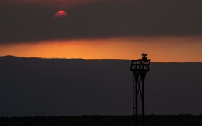 The sun glows behind smoke from the Oregon Bootleg Fire, just before sunset on 23 July, in Paisley, Oregon.