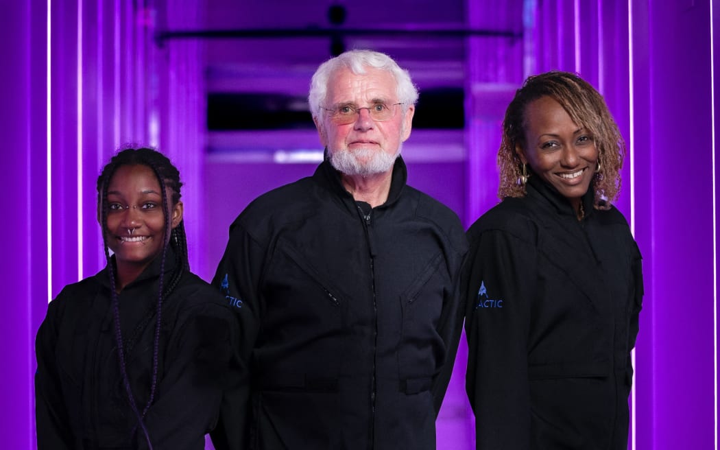 In this undated handout image provided by Virgin Galactic on August 10, 2023, the three passengers who will take part in Virgin Galactic's private astronaut mission Galactic 02 (L-R) Anastatia Mayers, 18, Jon Goodwin, 80, and Keisha Schahaff, 46, stand for a photo. Virgin Galactic launched its first tourist passengers into the weightlessness of space Thursday, the culmination of a nearly two-decade commercial pursuit, the company said. The three passengers -- Jon Goodwin, Keisha Schahaff, and her teenage daughter Anastatia Mayers -- floated gravity-free through the Virgin spacecraft about 45 minutes after taking off. (Photo by Virgin Galactic / AFP) / RESTRICTED TO EDITORIAL USE - MANDATORY CREDIT "AFP PHOTO / Virgin Galactic" - NO MARKETING NO ADVERTISING CAMPAIGNS - DISTRIBUTED AS A SERVICE TO CLIENTS