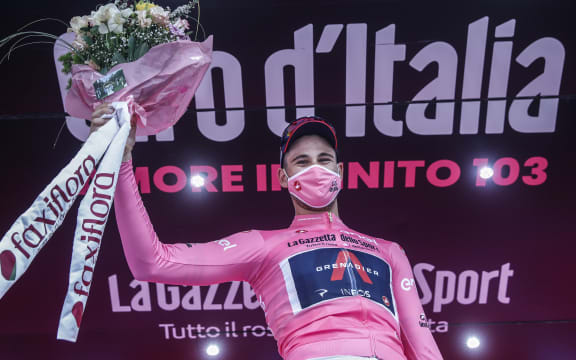 Team Ineos rider Italy's Filippo Ganna, wearing the overall leader's pink jersey, celebrates on the podium after winning the first stage of the Giro d'Italia 2020 cycling race