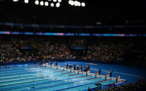 A photo taken with a tilt and  shift lens shows swimmers as they compete in the final of the women's 200m freestyle swimming event during the Paris 2024 Olympic Games at the Paris La Defense Arena in Nanterre, west of Paris, on July 29, 2024. (Photo by SEBASTIEN BOZON / AFP)
