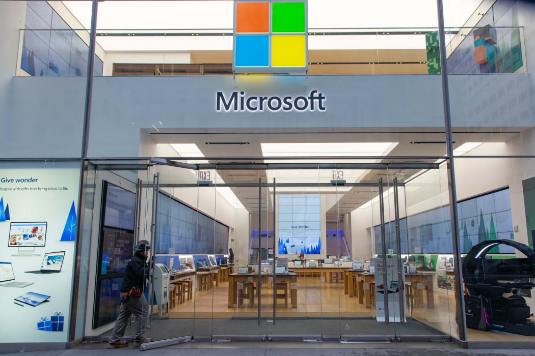 People walk past a Microsoft store entrance with the company's logo on top in midtown Manhattan at the 5th avenue in New York City, US, on 11 November 2019.