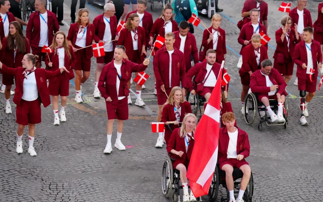 La delegación de Dinamarca marcha por la avenida de los Campos Elíseos durante la ceremonia de apertura de los Juegos Paralímpicos París 2024 el 28 de agosto de 2024 en París. (Foto: Dimitar DILKOFF / AFP)