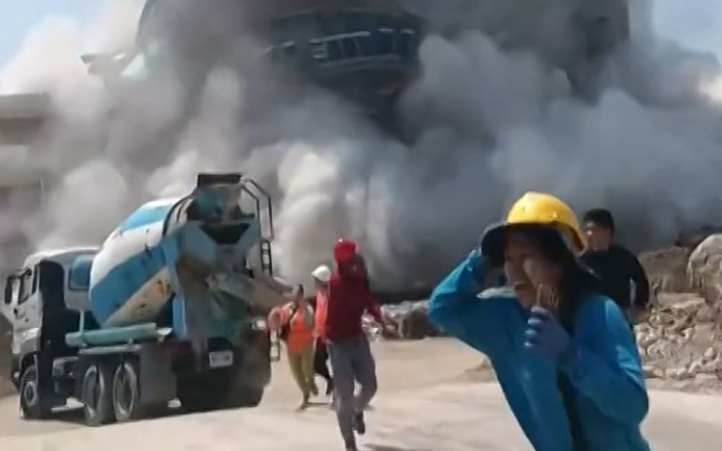 This frame grab from UGC video footage taken and posted by Khon Su Cheevit Adeet Mai Suay Rok Na on Facebook on March 28, 2025 shows workers running away from a building as it collapses at a construction site in Bangkok, following an earthquake. A powerful earthquake rocked central Myanmar on March 28, buckling roads in capital Naypyidaw, damaging buildings and forcing people to flee into the streets in neighbouring Thailand. (Photo by Handout / Courtesy of Facebook user Khon Su Cheevit Adeet Mai Suay Rok Na / AFP) / NO USE AFTER APRIL 11, 2025 12:29:17 GMT - NO USE AFTER APRIL 11, 2025 12:29:17 GMT - -----EDITORS NOTE --- RESTRICTED TO EDITORIAL USE - MANDATORY CREDIT "AFP PHOTO / COURTESY OF FACEBOOK USER KHON SU CHEEVIT ADEET MAI SUAY ROK NA " - NO MARKETING - NO ADVERTISING CAMPAIGNS - DISTRIBUTED AS A SERVICE TO CLIENTS  - NO ARCHIVES /