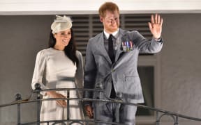 Britain's Prince Harry and and his wife Meghan, the Duchess of Sussex wave from the balcony of the Grand Pacific Hotel in Suva, Fiji.