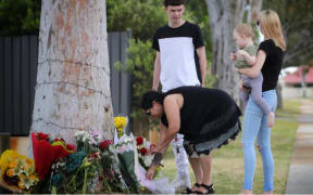 Mourners lay flowers at a memorial for Cassius Turvey on Patterson Road in Middle Swan.