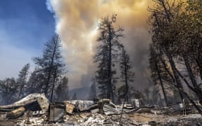 Destroyed property is left in its wake as the Oak Fire chews through the forest near Midpines, northeast of Mariposa, California, on July 23, 2022. - The fire is burning west of Yosemite National Park where the Washburn Fire has threatened the giant sequoia trees of the Mariposa Grove. (Photo by DAVID MCNEW / AFP)
