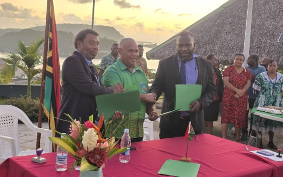 Vanuatu prime minister Jotham Napat (middle) and Vanuatu Teachers Union secretary general (right) celebrate the new collective bargaining agreement bringing the 18-month teachers' strike to an end. December 22, 2025.