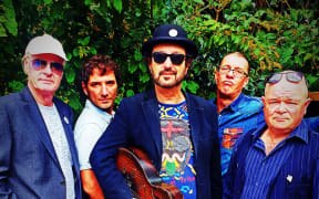 The Tauranga band Kokomo standing in front of foliage.