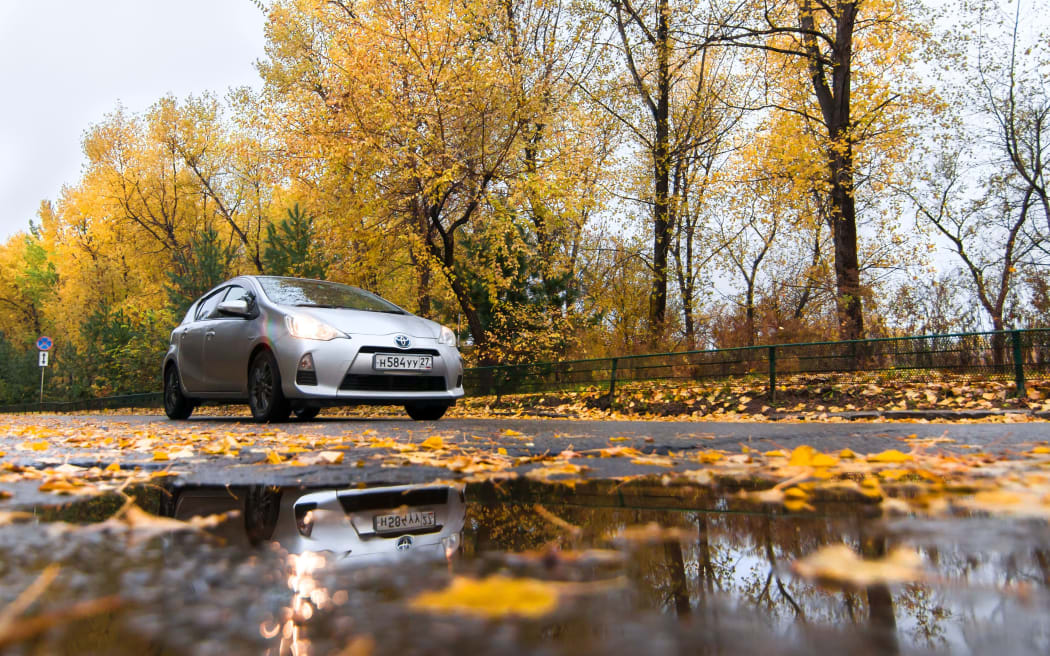 KHABAROVSK, RUSSIA - OCTOBER 14, 2017: Silver Toyota Aqua on autumn road in rainy day