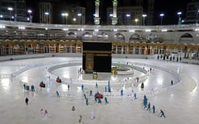 In this file photo taken on April 24, 2020, sanitation workers disinfect the area around the Kaaba in Mecca's Grand Mosque, on the first day of the Islamic holy month of Ramadan, amid unprecedented bans on family gatherings and mass prayers due to the coronavirus (COVID-19) pandemic.