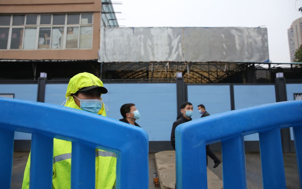 Chinese security guards check at the gate of Huanan Seafood Wholesale Market  after a vehicle carrying members of World Health Organizaion (WHO) entered the market.