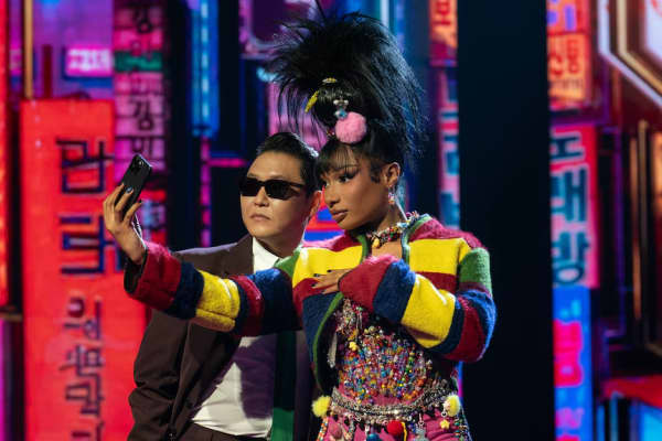 Two people in colourful clothes pose for a selfie.