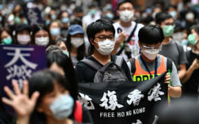 Protesters march on a road during a pro-democracy rally against a proposed new security law