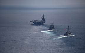 The aircraft carrier USS Carl Vinson (L) leading the Arleigh Burke-class guided-missile destroyer USS Michael Murphy in South Korean waters.