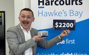 Auctioneer Brayden Coldicutt with the block of butter that sold for more than $2000.