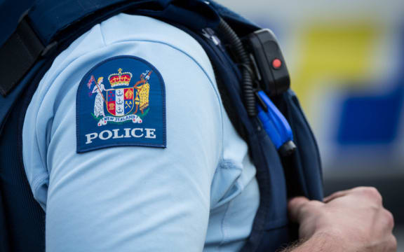 Close up of a police officer at an incident on a residential street. 6 July 2016.
