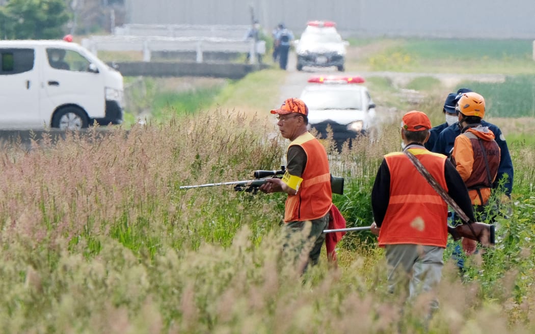 Hunters and police searching for a bear on on 18 June, 2021, after it appeared in Sapporo City, Hokkaido, and four people were attacked and injured.
