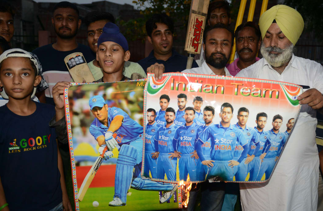 Indian cricket fans burn posters of Indian cricket players during a protest in reaction to the  national cricket team poor performance during the first semifinal between India and New Zealand at Old Trafford in Manchester of the 2019 ICC World Cup, in Amritsar June 10, 2019.