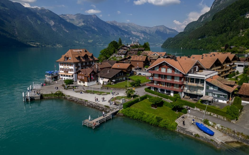 A picture taken on June 2, 2023 shows the village of Iseltwald at the shore of Lake Brienz, in the Swiss Alps. Ever since a hugely popular South Korean series on Netflix featured a romantic scene in this very spot, the picturesque lakeside village of Iseltwald, with a population of around 400 people, has found itself overrun by tourists. They are fans of "Crash Landing on You", which tells the surreal and unlikely story of a South Korean billionaire heiress who accidentally paraglides into the peninsula's demilitarised zone, crashing into a chivalrous army officer serving North Korean leader Kim Jong Un. (Photo by Fabrice COFFRINI / AFP)