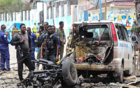 Security officers patrol on the site of a car-bomb attack in Mogadishu on 25 September 2021.
