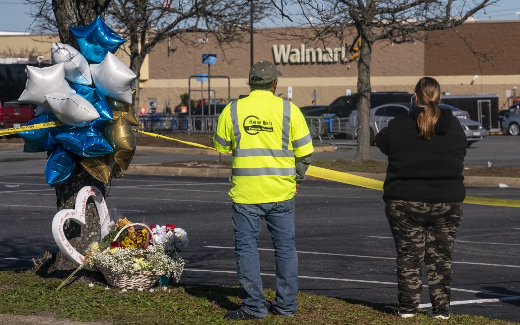 Onlookers watch as law enforcement investigates the site of a fatal shooting in a Walmart on November 23, 2022 in Chesapeake, Virginia. Following the Tuesday night shooting, six people were killed, including the suspected gunman.