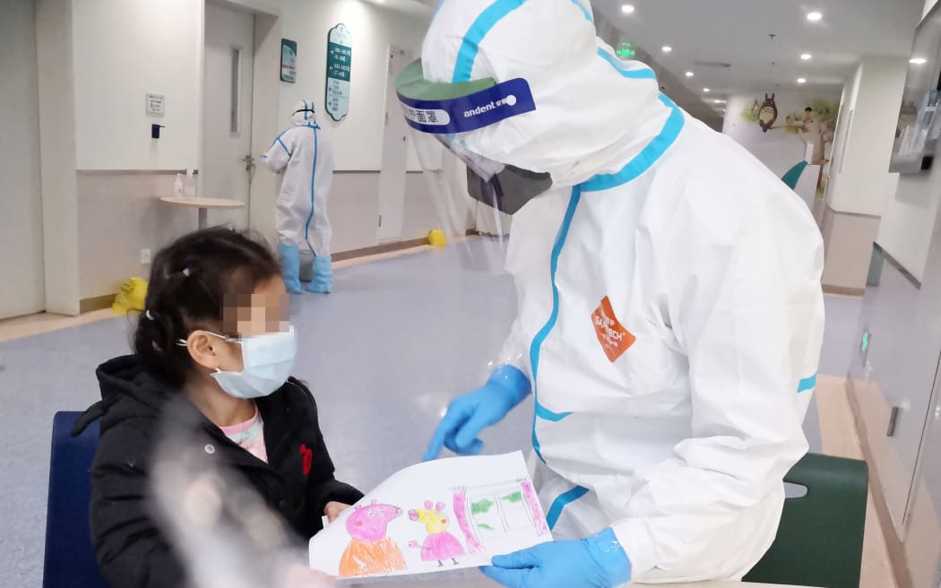 A nurse Yang Liu receiving a painting as a gift from a child infected with novel coronavirus pneumonia at a ward in Wuhan Children's Hospital in Wuhan.