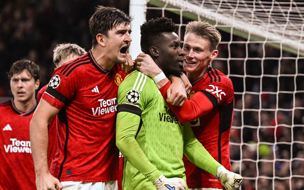 Manchester United's goalkeeper Andre Onana celebrates with Manchester United's Harry Maguire and teammates after saving a penalty kick.