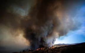 Flames race up the hill as the plume of smoke from the Hughes Fire fills the sky in Castaic, a northwestern neighborhood of Los Angeles, California, on January 22, 2025. A new wildfire erupted north of Los Angeles on January 22, exploding in size and sparking thousands of evacuation orders in a region already staggering from the effects of huge blazes.
Ferocious flames were devouring hillsides near Castaic Lake, spreading rapidly to cover 5,000 acres (2,000 hectares) in just over two hours.
The fire was being fanned by strong, dry Santa Ana winds that were racing through the area, pushing a vast pall of smoke and embers ahead of the flames.
Evacuations were ordered for 19,000 people all around the lake, which sits around 35 miles north of Los Angeles, and close to the city of Santa Clarita. (Photo by Apu GOMES / AFP)