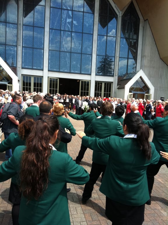 Karamu High School students perform a haka as Sir Paul's casket is brought out of the church.