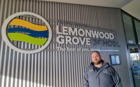 Lemonwood Grove School Principal Blair Dravitski pictured with the school's branding on the wall of the school's reception.