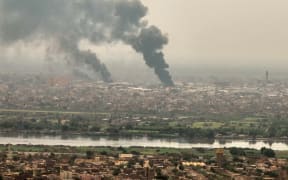An image grab taken from AFPTV video footage on 28 April, 2023, shows black smoke rising over Sudan's capital Khartoum. Foreign nations scrambled to organise mass evacuations of their citizens as the fighting continued, with Turkey's defence ministry reporting one of its military transport aircraft had come under fire.