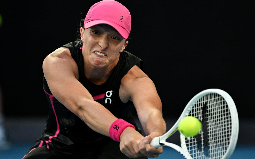 Poland's Iga Swiatek hits a return against Czech Republic's Linda Noskova during their women's singles match on day seven of the Australian Open tennis tournament in Melbourne on January 20, 2024. (Photo by Anthony WALLACE / AFP) / -- IMAGE RESTRICTED TO EDITORIAL USE - STRICTLY NO COMMERCIAL USE --