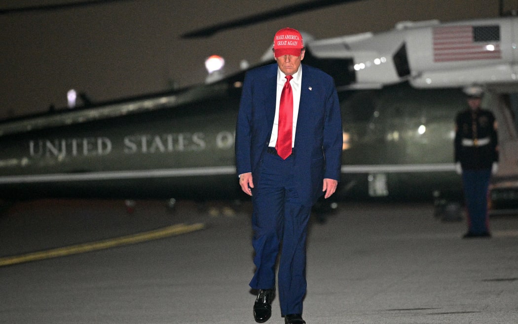 US President Donald Trump steps off Marine One and walks to board Air Force One before departing Miami International Airport, in Miami, Florida on April 3, 2025. Trump is travelling to his Mar-a-Lago Resort. (Photo by Mandel NGAN / AFP)