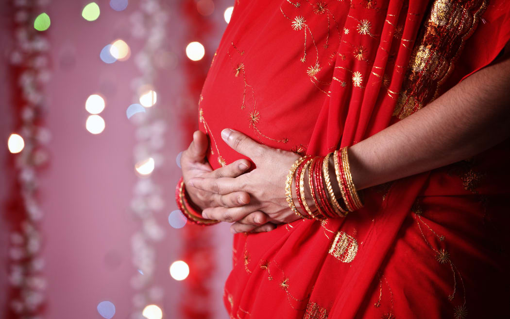 Close up of Indian woman touching her tummy