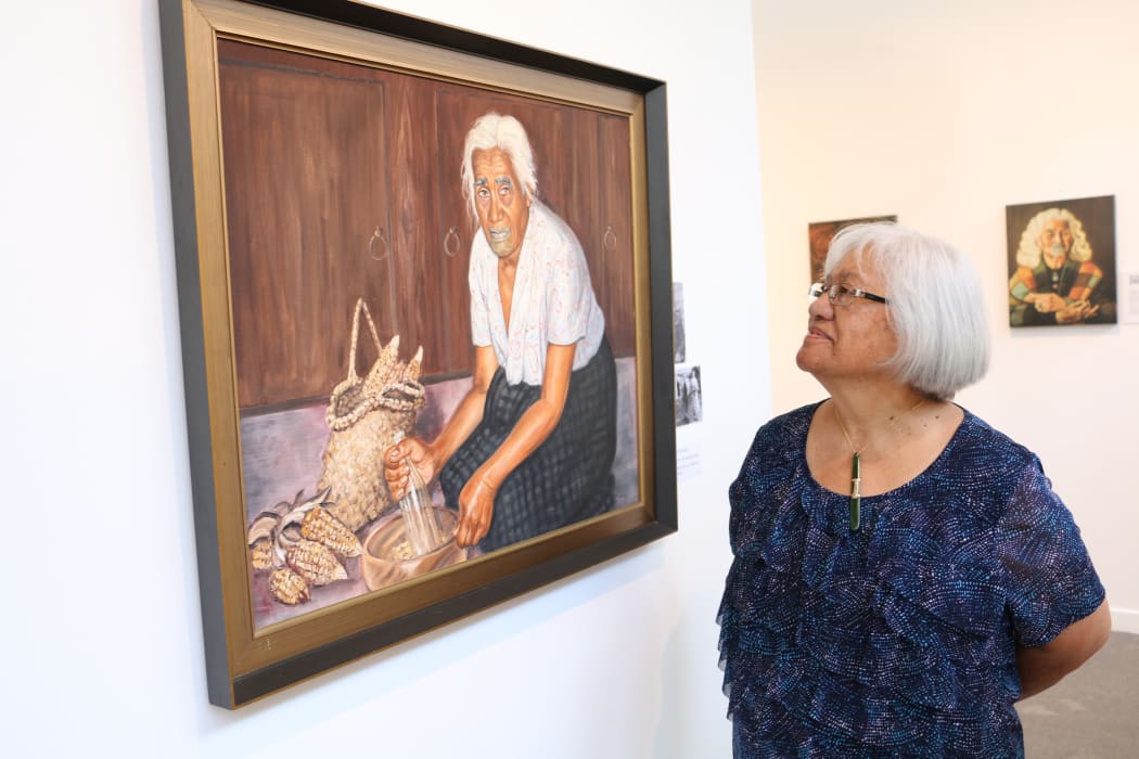 Rovina Tata next to the portrait of her Kuia Makarita Hose.