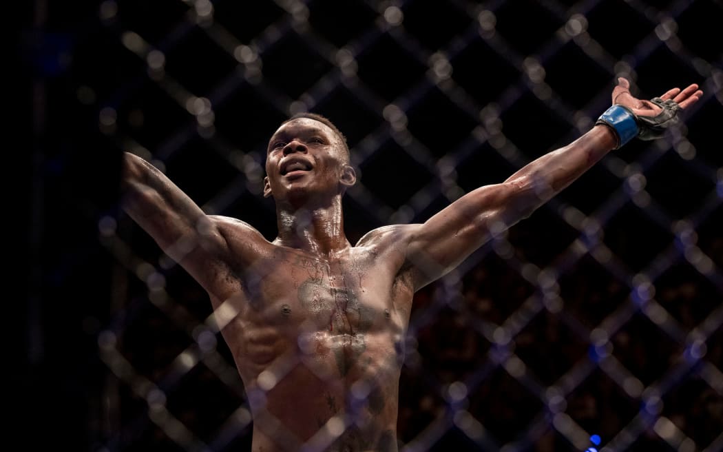UFC middleweight champion Israel Adesanya celebrates victory inside the octagon in 2018.