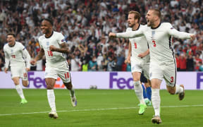 England's defender Luke Shaw (R) celebrates after scoring the first goal during the UEFA EURO 2020 final football match between Italy and England at the Wembley Stadium in London on July 11, 2021. (Photo by Andy Rain / POOL / AFP)
