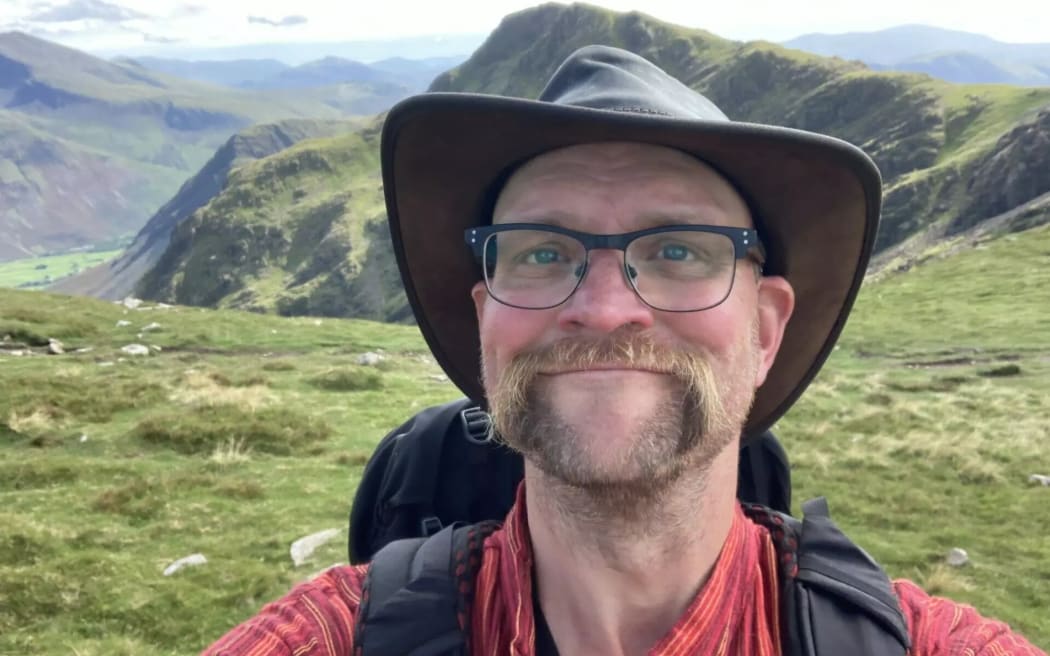 Jonas Skogscroll with a pack on his back and hills in the background