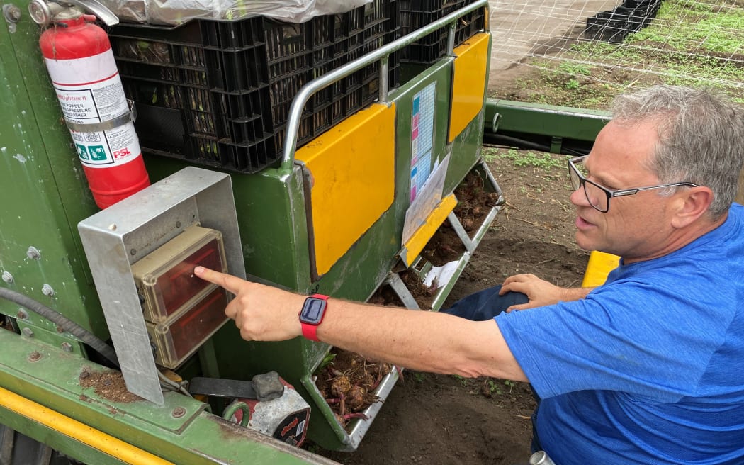 Colin Birch shows how the lily bulb planting machine works.