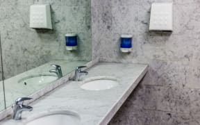public toilets with mirrors, marble top, soap dispenser and a fan to dry