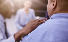Closeup of unrecognizable African man comforting woman during group therapy session with psychologist, copy space