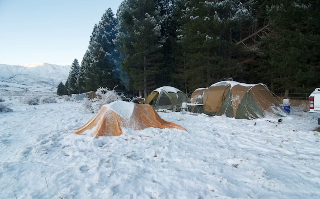 Heavy snow covers a camp, showing how challenging the environment can be.